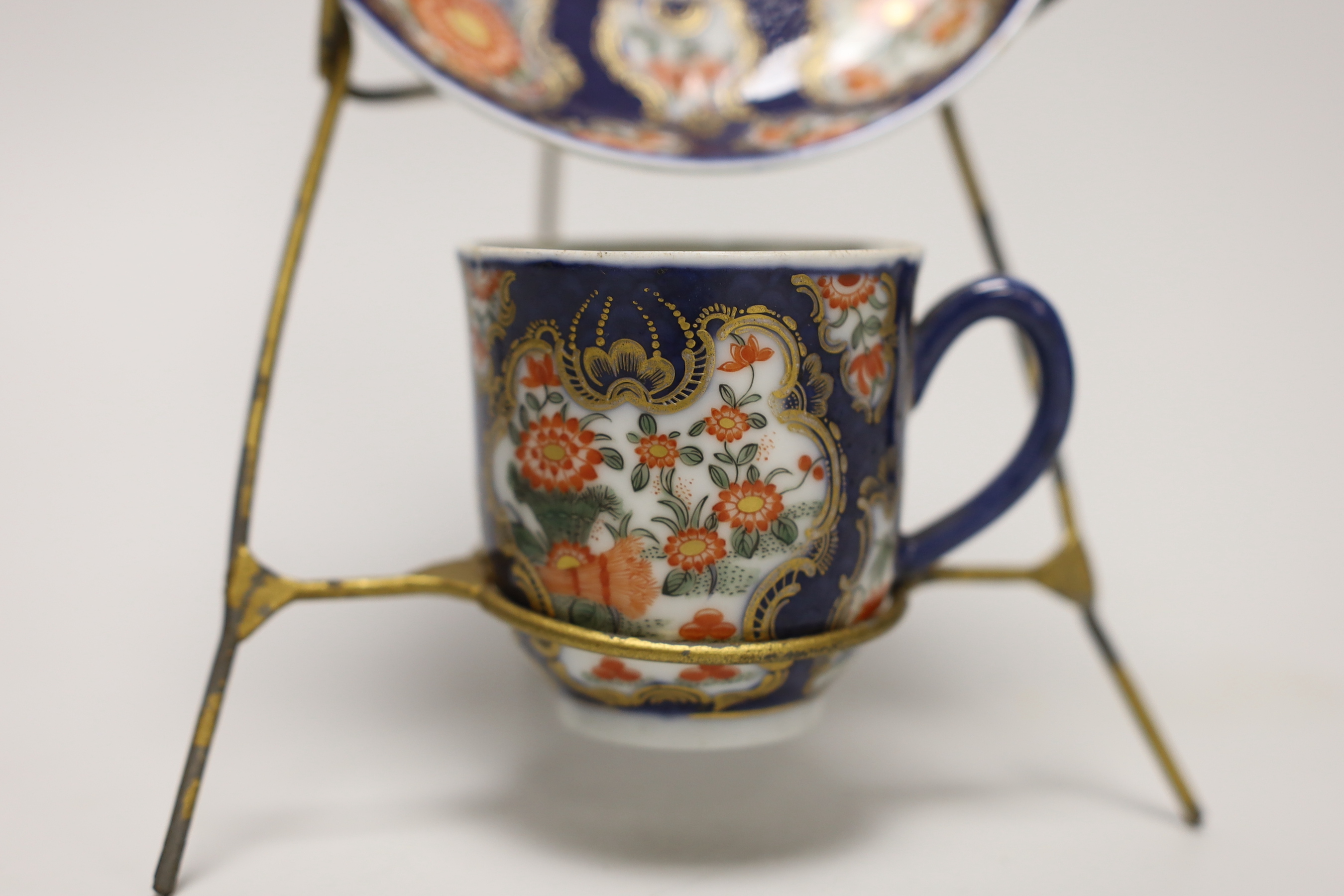 A Samson replica of a Worcester scale blue cup and saucer, hand painted with flowers on stand, the saucer 12cm in diameter